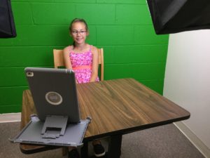 Girl sitting in front of an iPad.