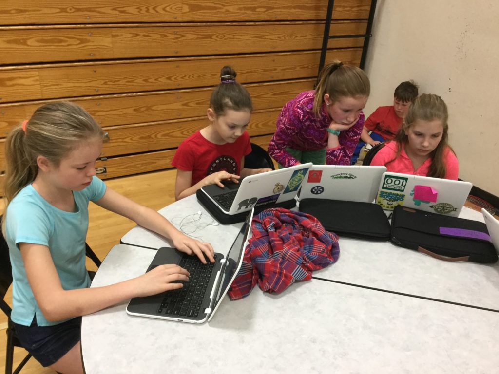 Students typing on laptops.