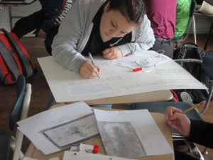 A student works diligently on a family tree at a desk