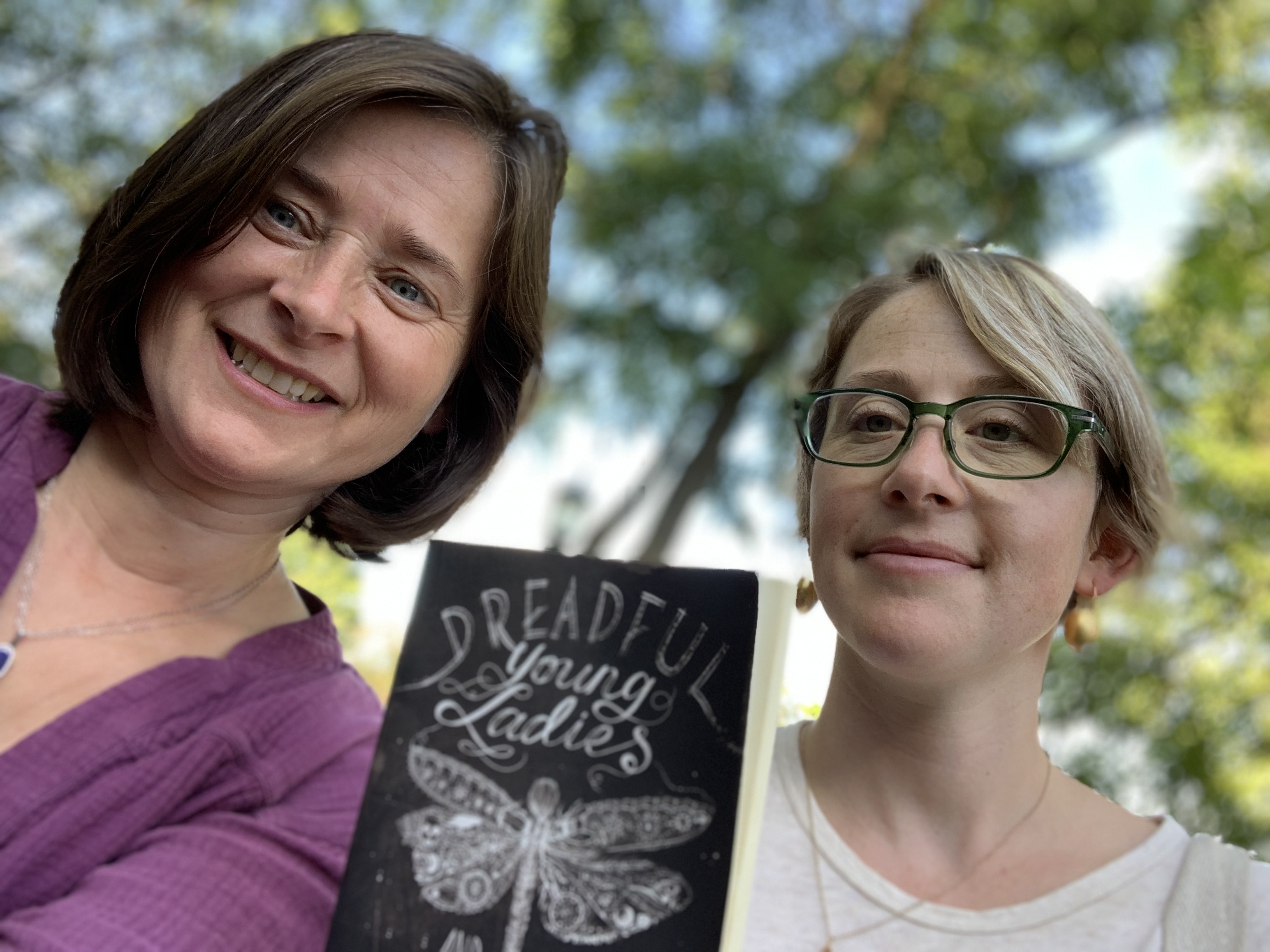 Jeanie Philips (l) and Sarah Birgé, with a copy of Dreadful Young Ladies and Other Stories, by Kelly Barnhill