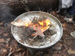 a fire smouldering in an upturned steel pan