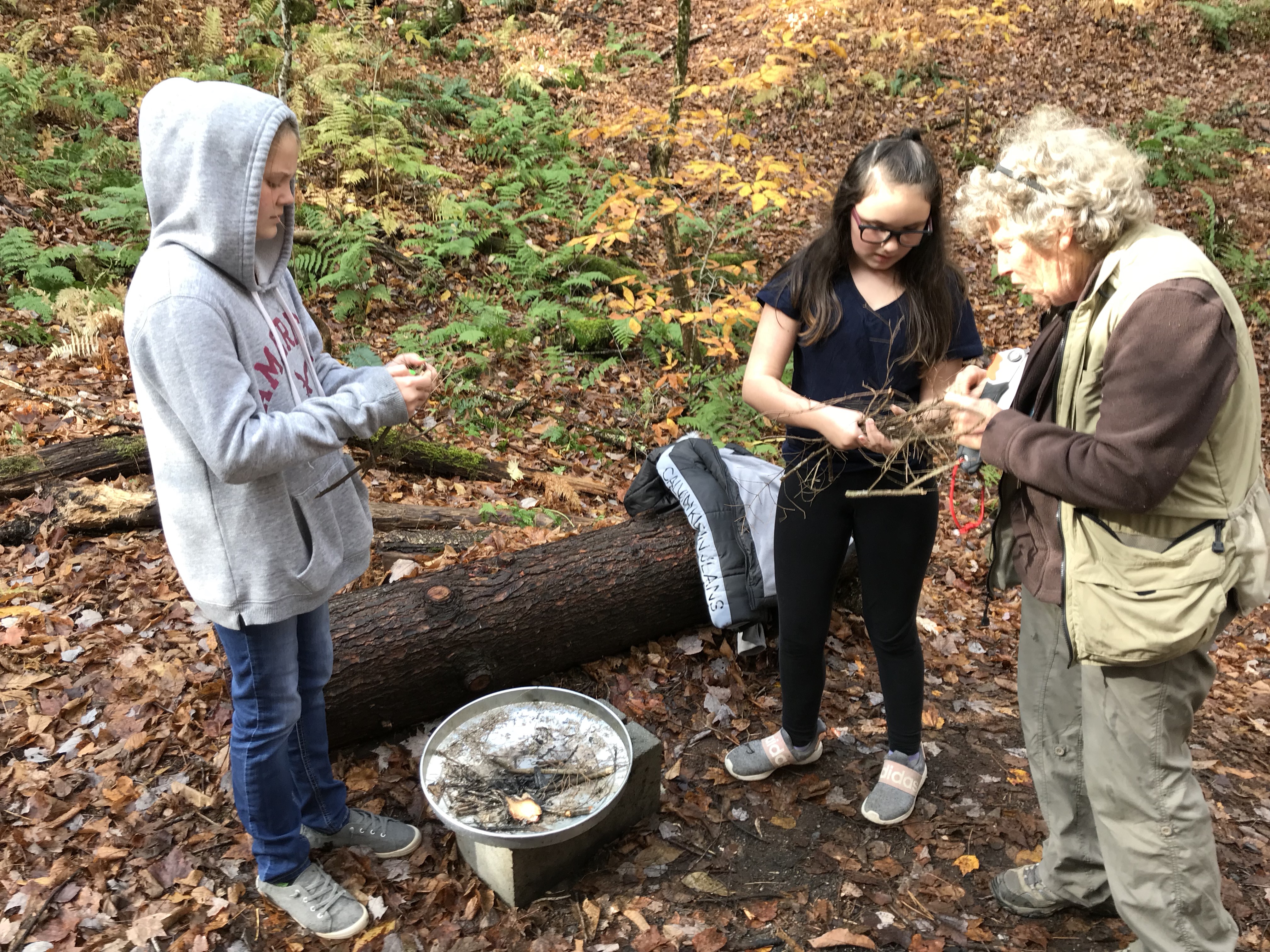 Students consult with an elder in the woods