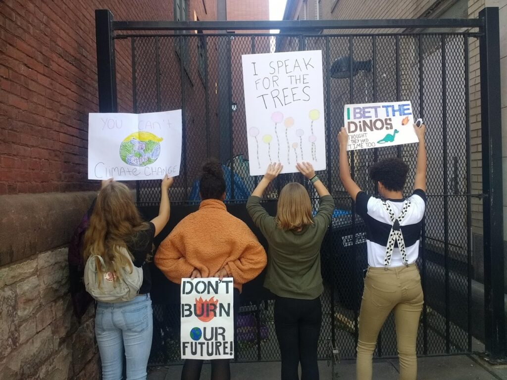 Students hold up homemade signs at the Youth Climate Strike in Burlington
