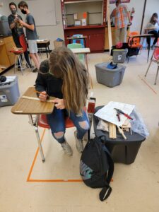A masked student works at a desk