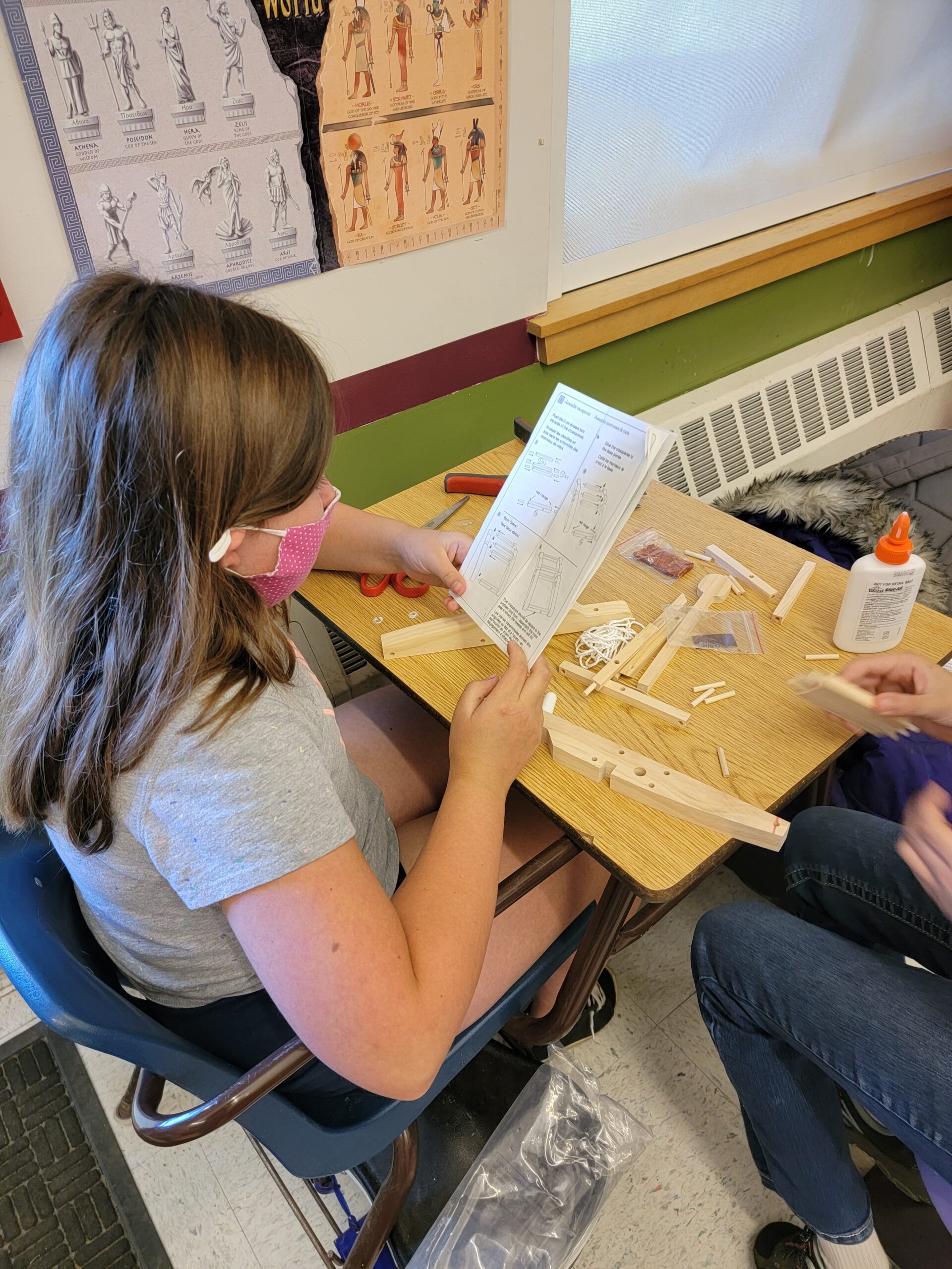 A masked student reads the instructions