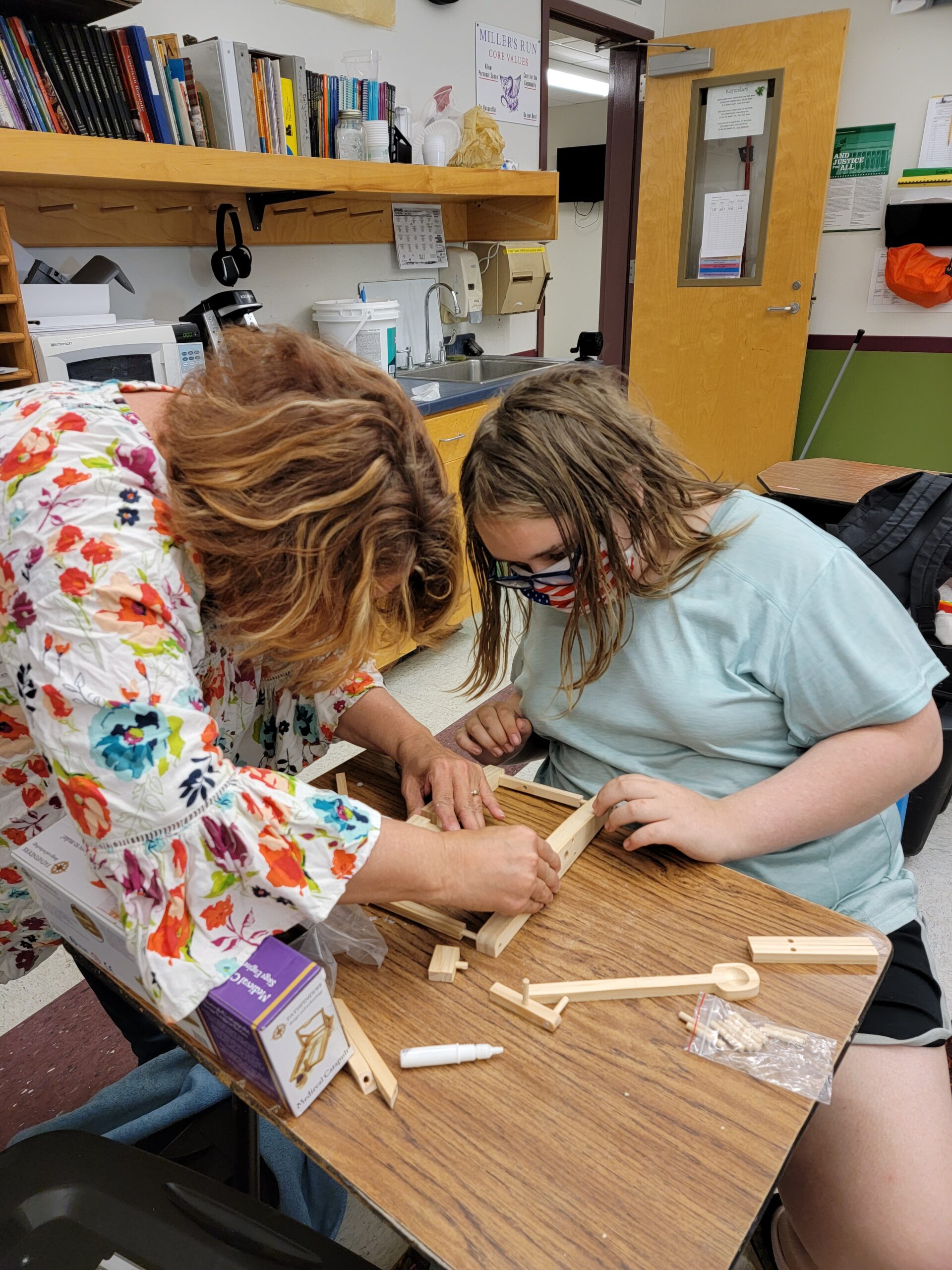 Two students work in miniature wood
