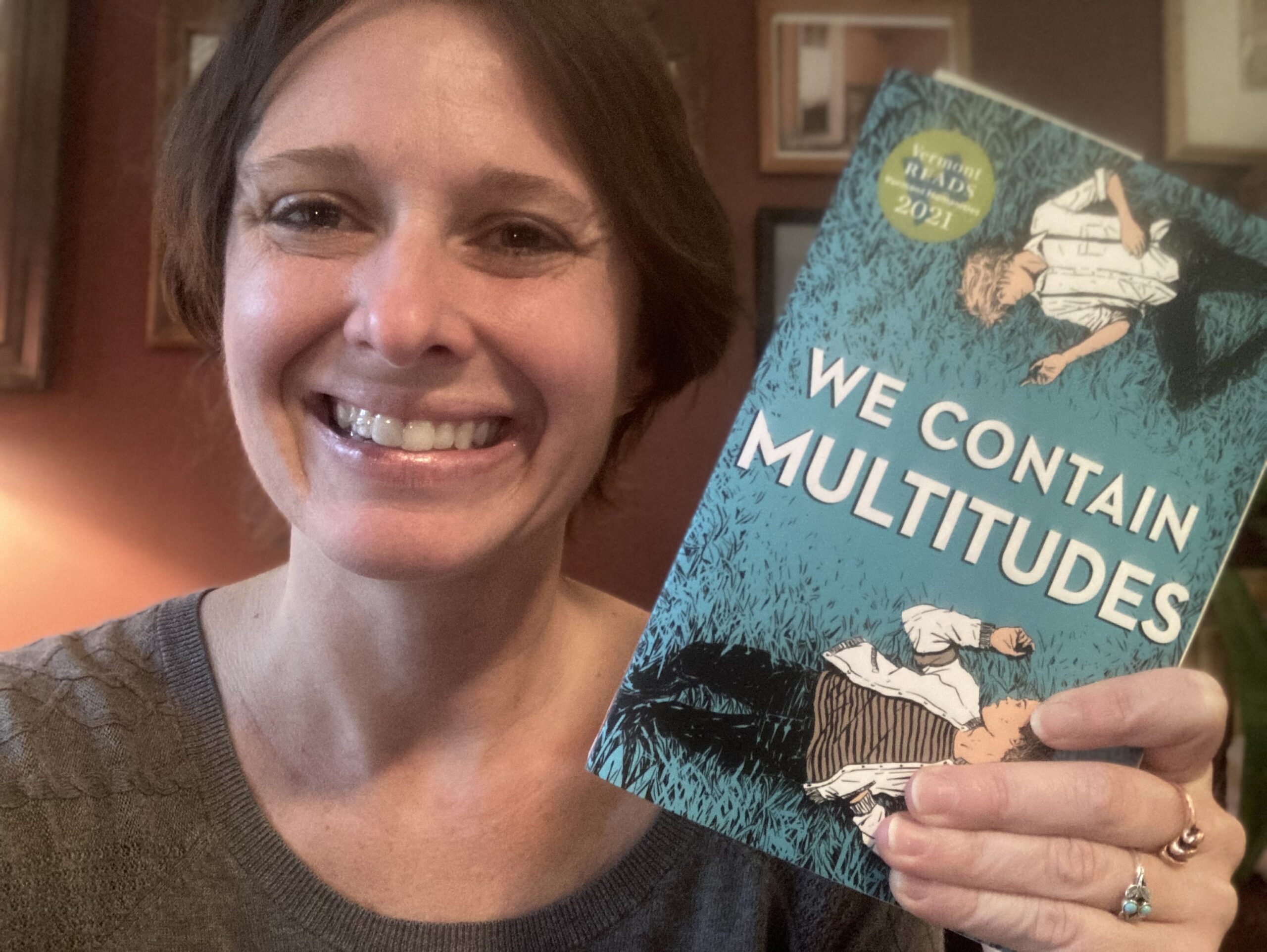 Lizzy Lyons with a copy of the book We Contain Multitudes
