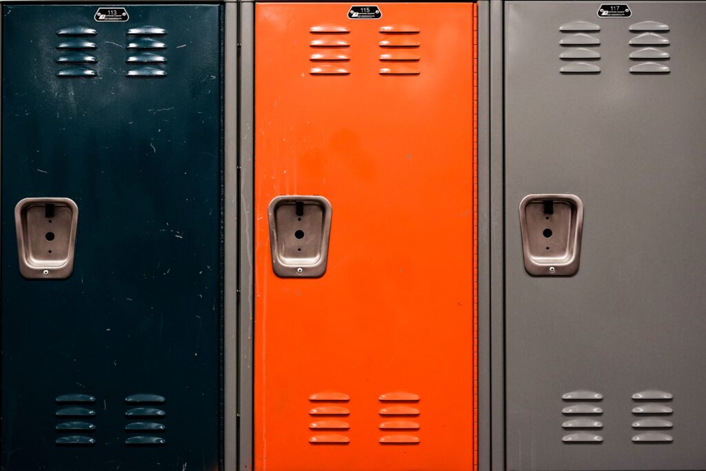 Three locker doors: black, orange, and gray