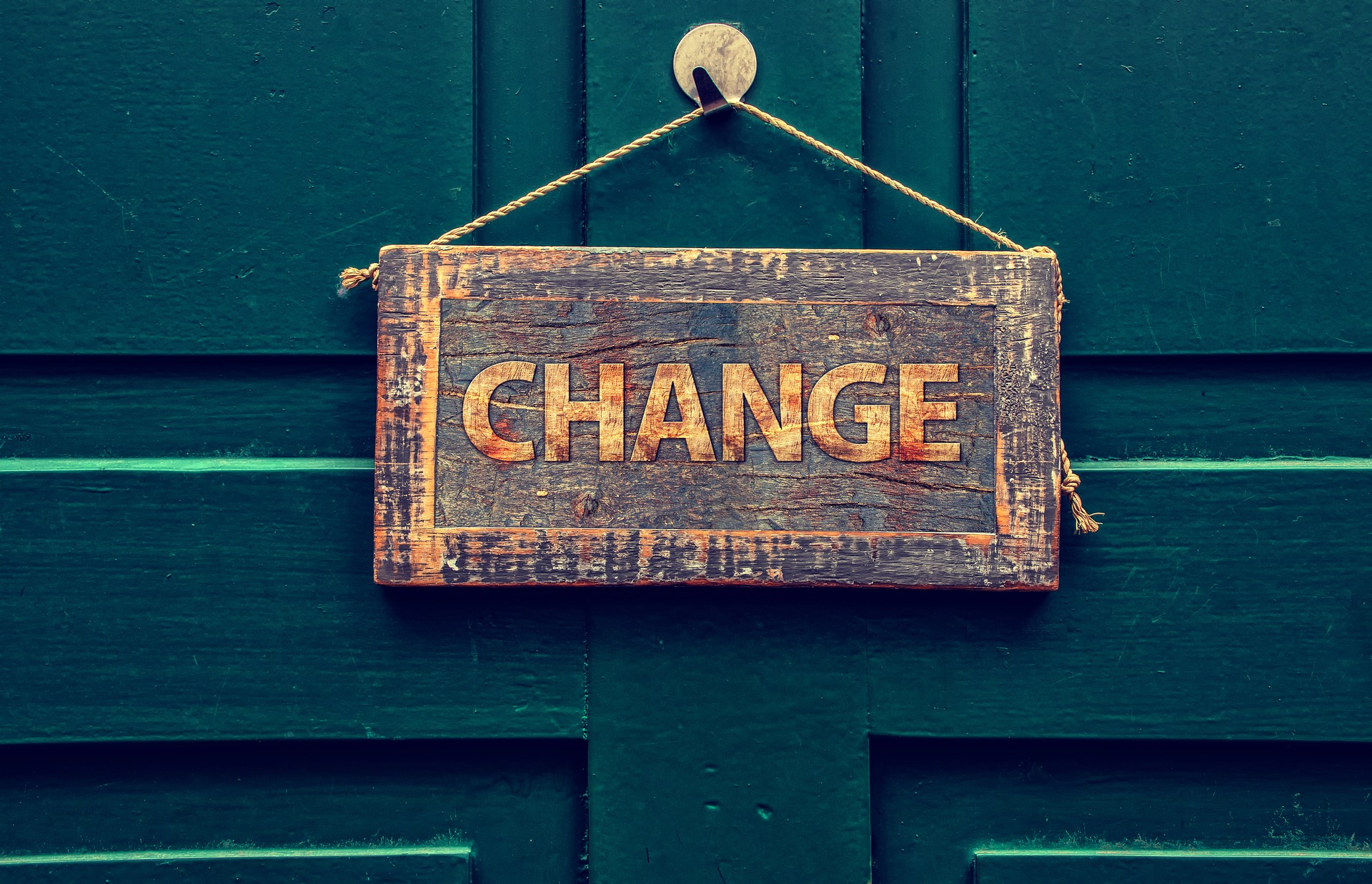A wooden sign reading "Change" hangs on a dark blue door