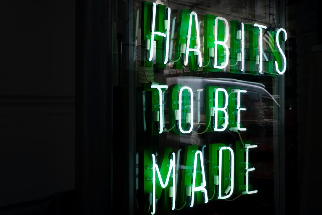 Photo of a neon sign reading "Habits to be made"
