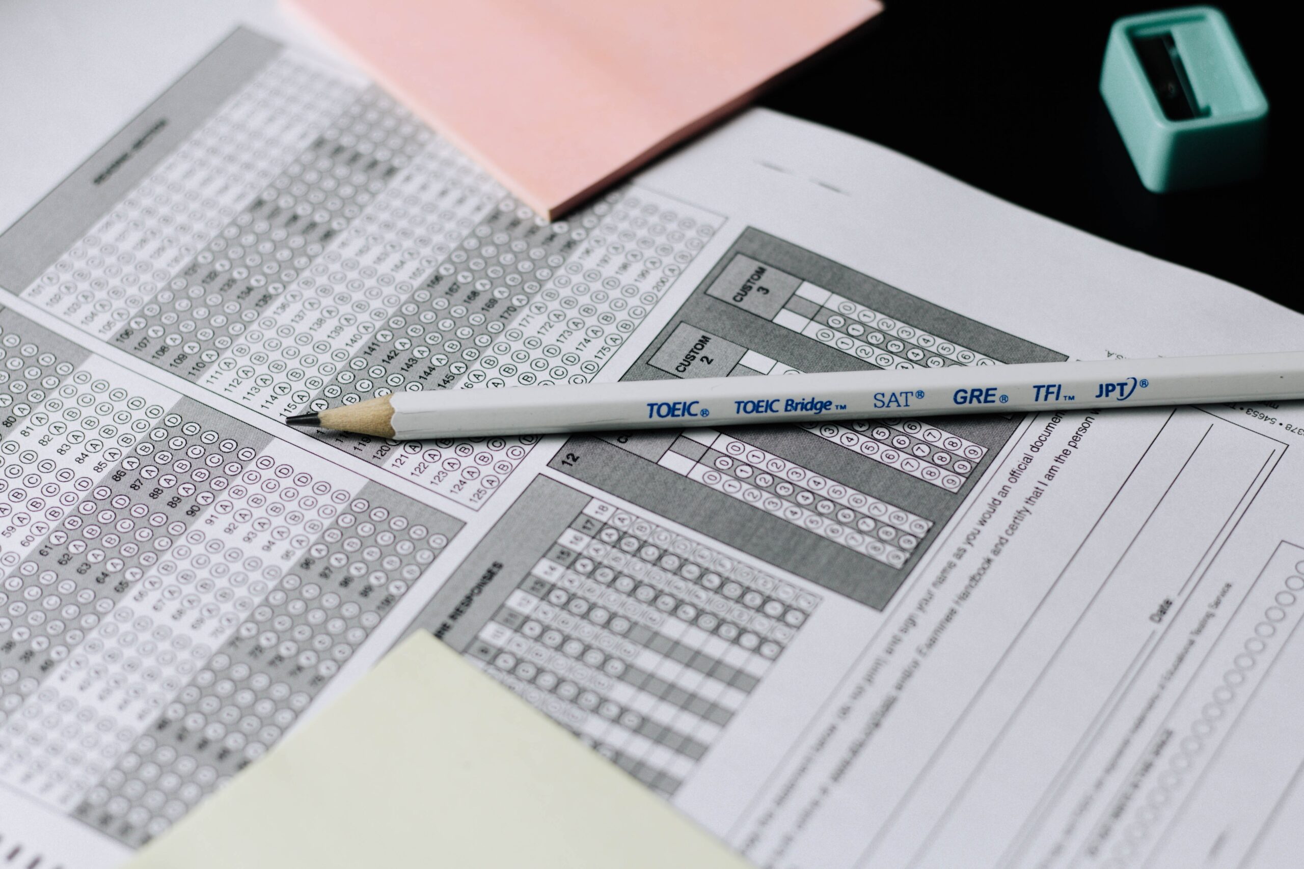 A pencil lies atop a pile of scantron sheets