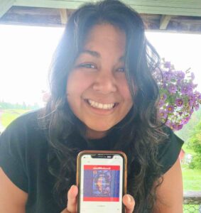 Ornella Matta Figuero holds up her phone showing the audiobook The Last Cuentista