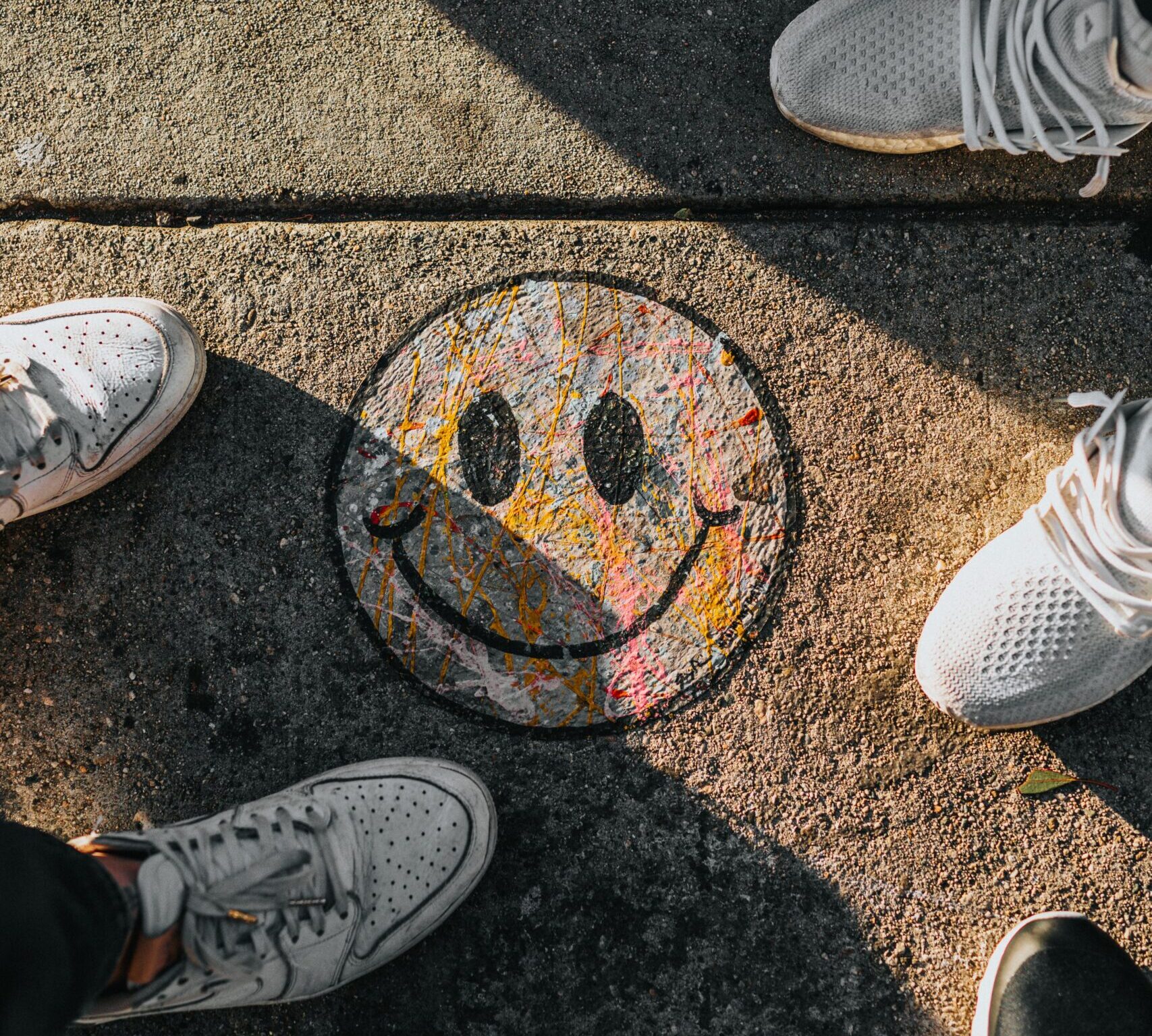 A smiley face graffiti on sidewalk
