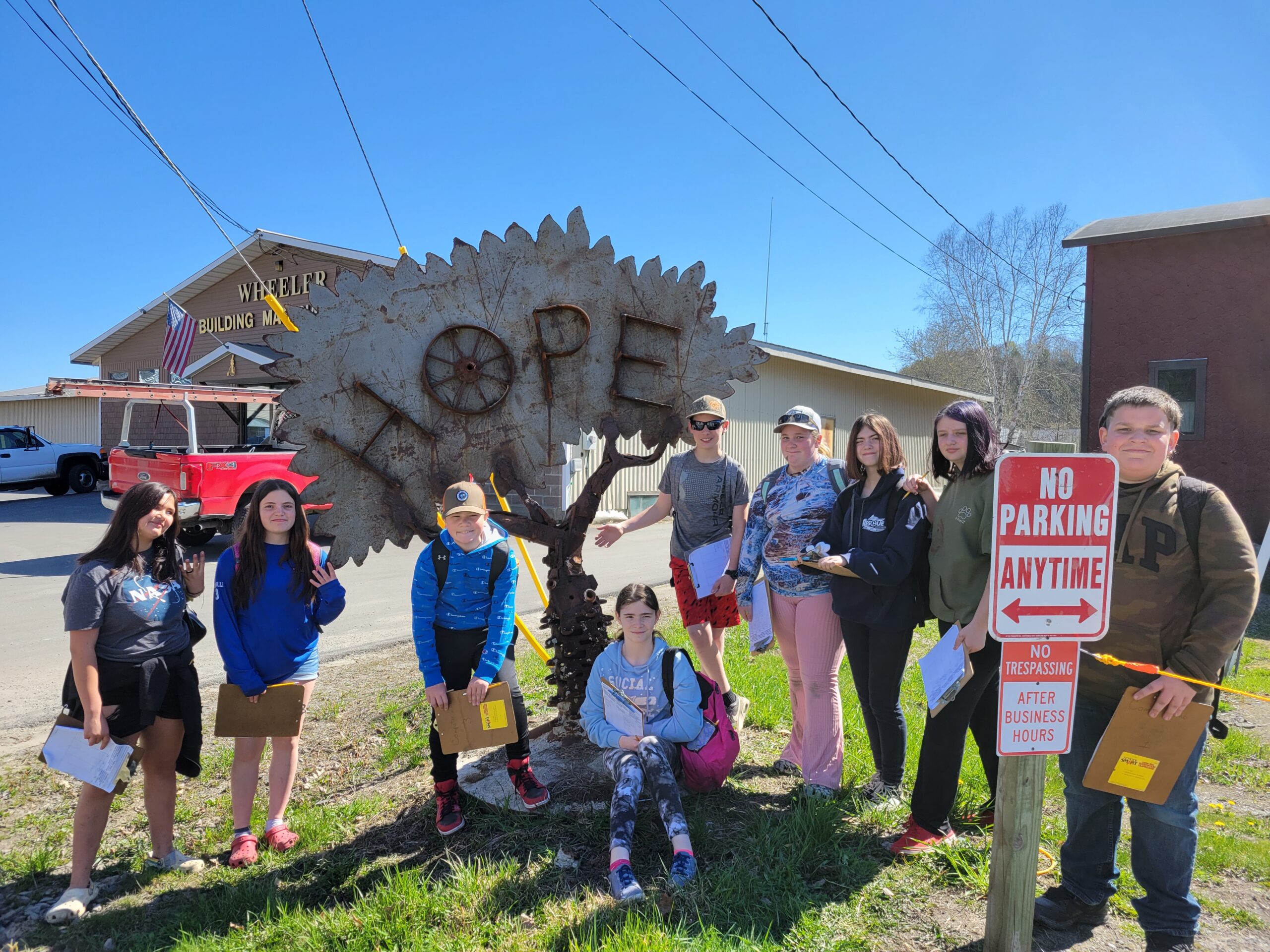 A group of students stand with a sculpture