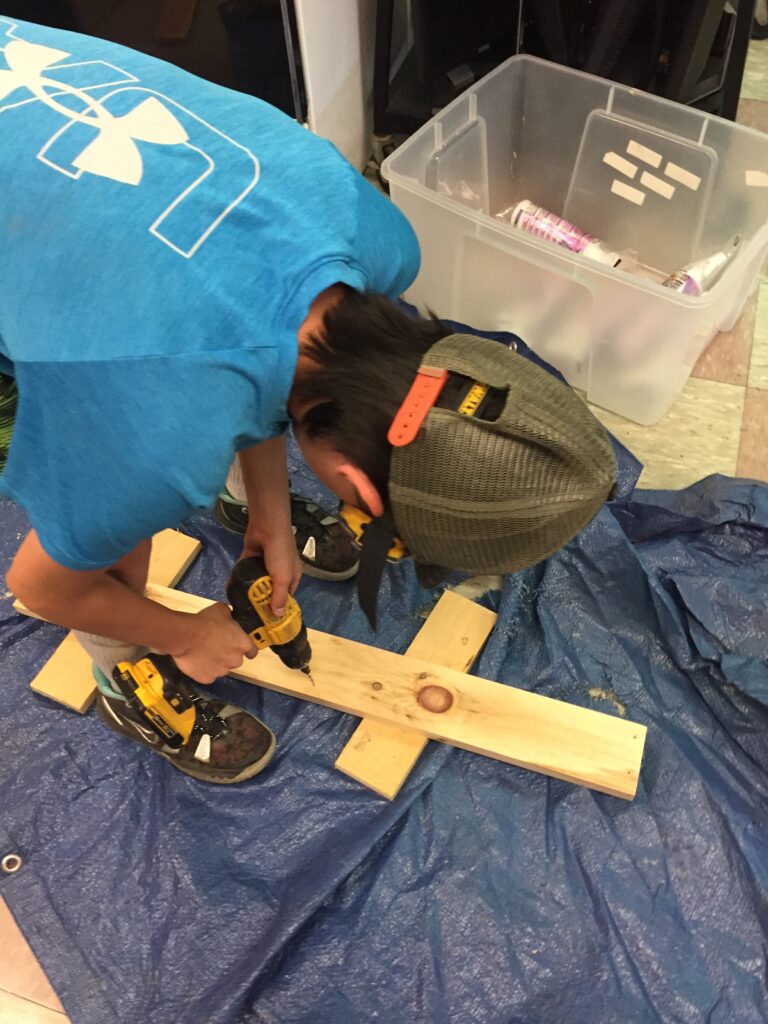 A student drills into a woodworking project