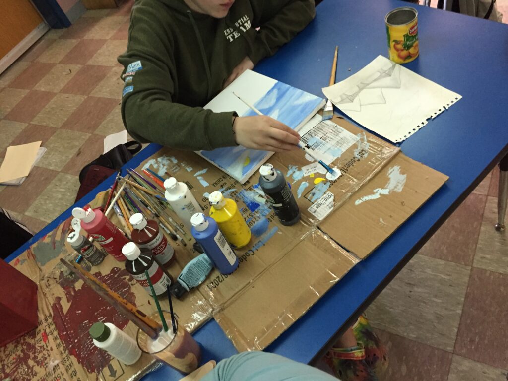 A student paints in a classroom
