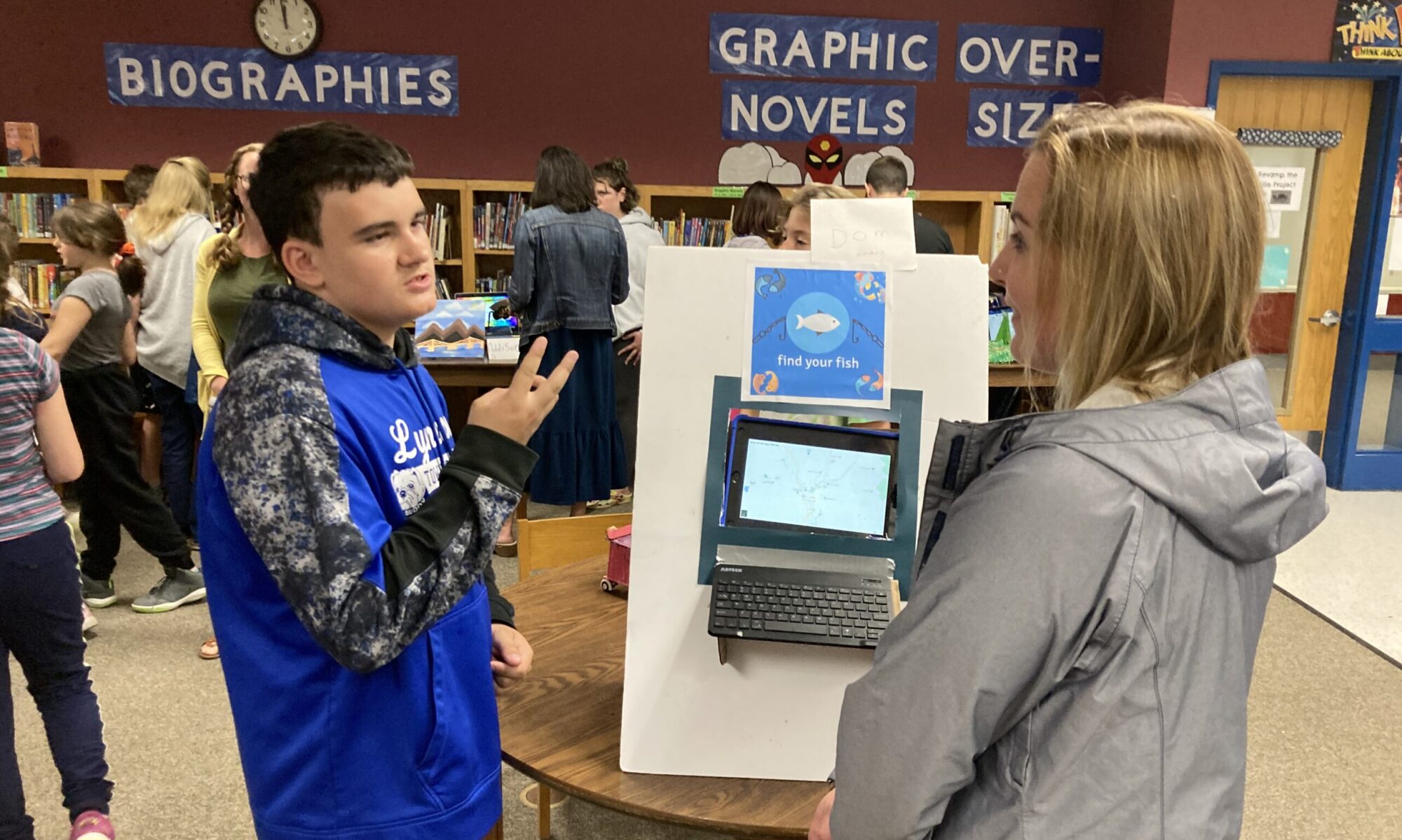 A student explains a project to an adult