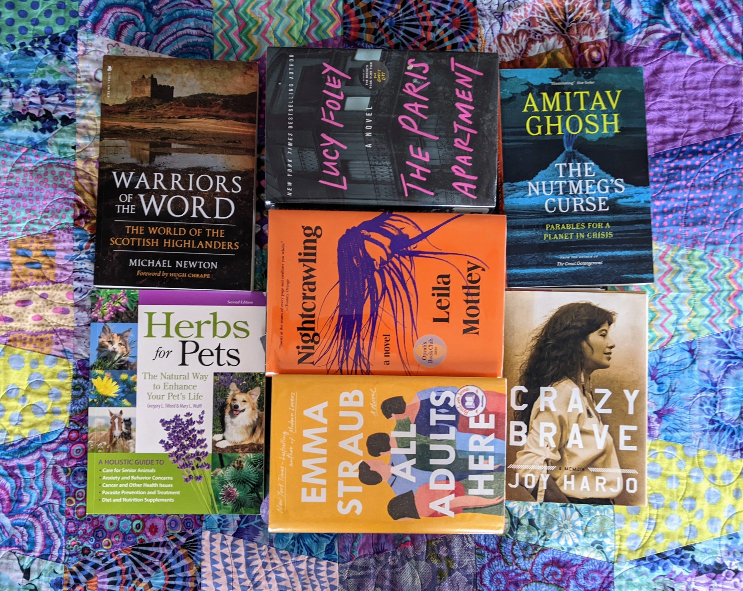 A pile of books on a brightly colored cloth