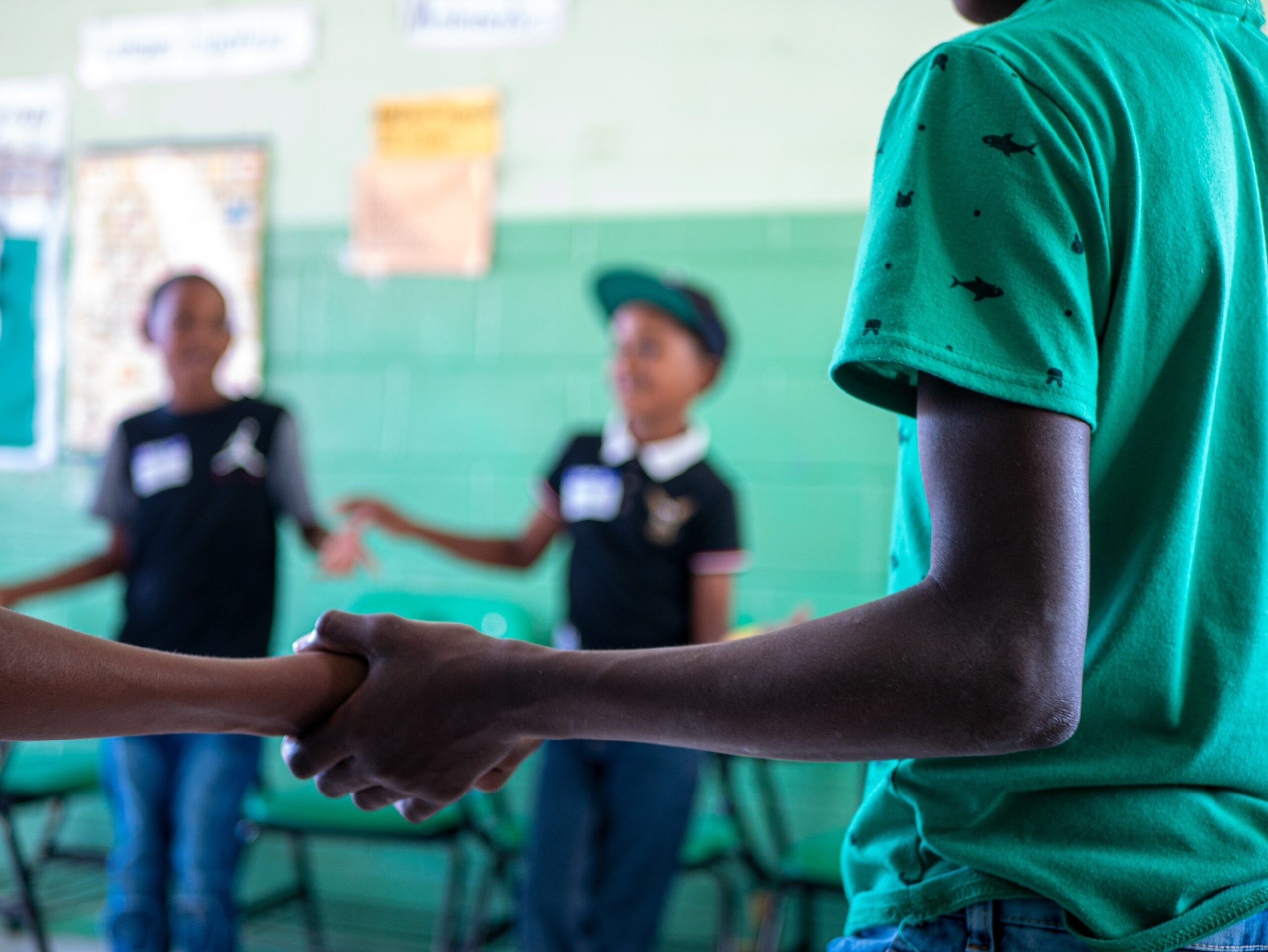 A group of students holds hands in a classroom
